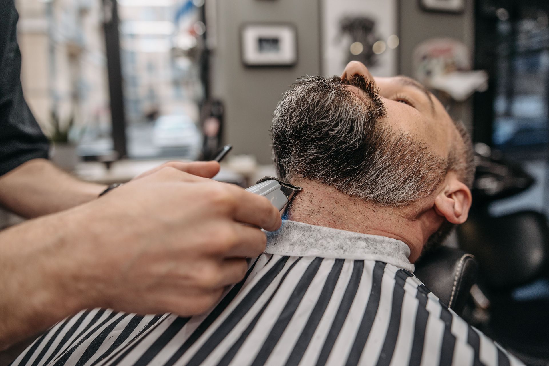 Close-up of a professional barber trimming a man's beard in a stylish barbershop.